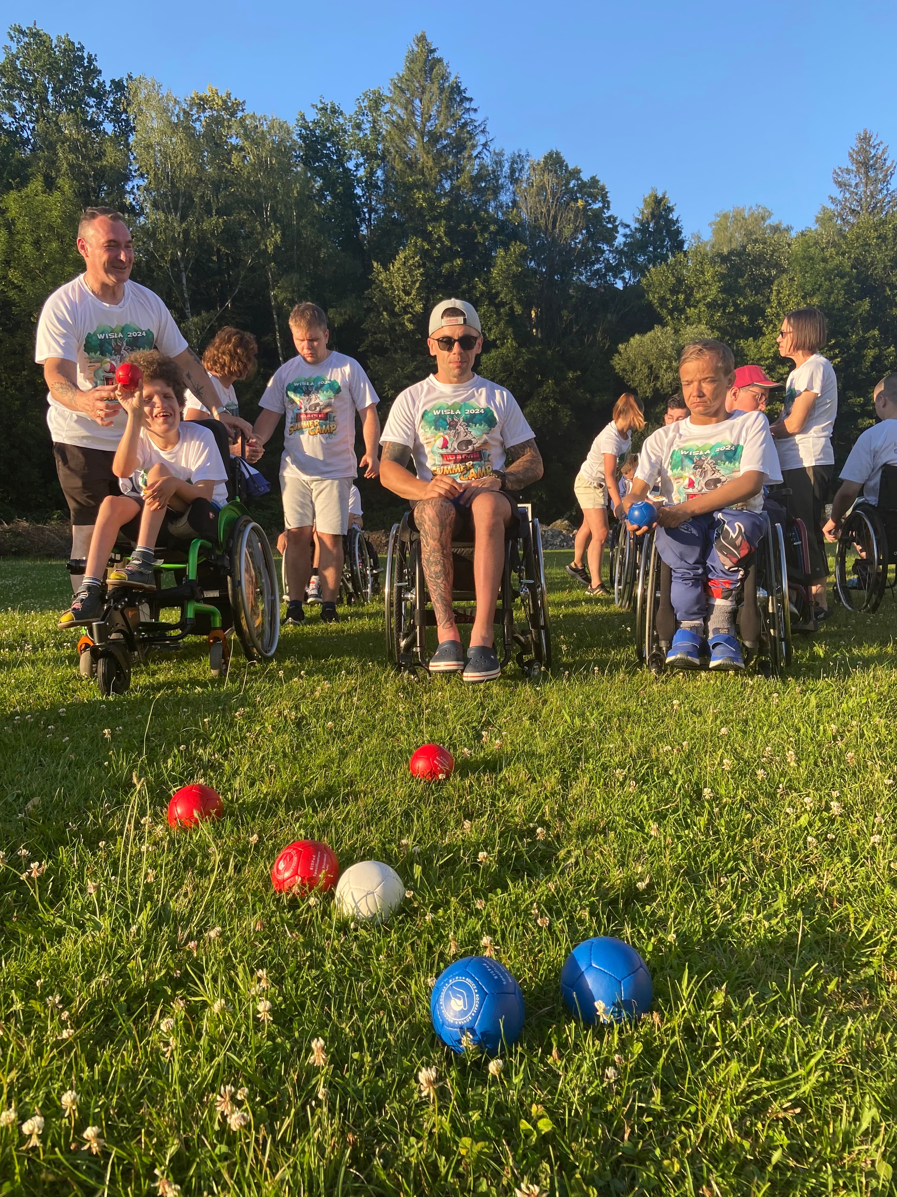 Chłopak z czerwoną piłką na wózku